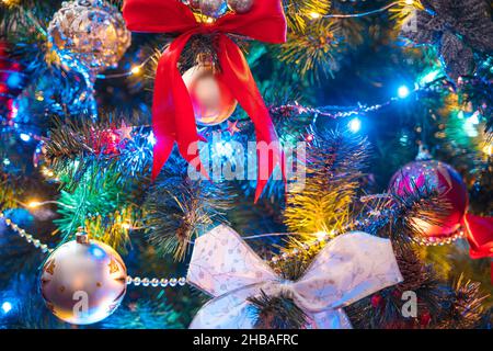 Christmas background. Colorful garlands, shiny balls and toys on the Christmas tree close-up. Selective focus. Stock Photo