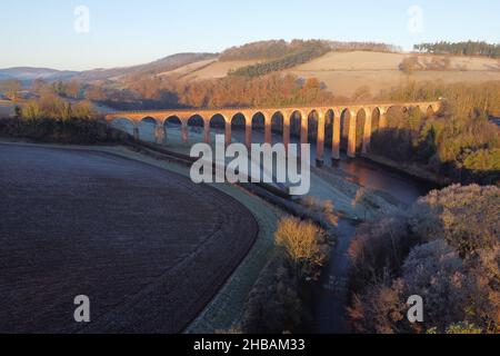Melrose, UK. 18th Dec, 2021. Early morning sunshine over the River Tweed in the Scottish Borders at Leaderfoot near to Melrose on Saturday 18 December 2021. The former viaduct that was recently seen as a backdrop to the latest Indiana Jones filming, bathed in early winters sunlight, low temperatures overnight aded to the frosty scene. ( Credit: Rob Gray/Alamy Live News Stock Photo