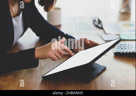 Businesswoman using digital tablet, woman using tablet to search internet, using tablet for business planning, blank screen tablet, modern office, clo Stock Photo