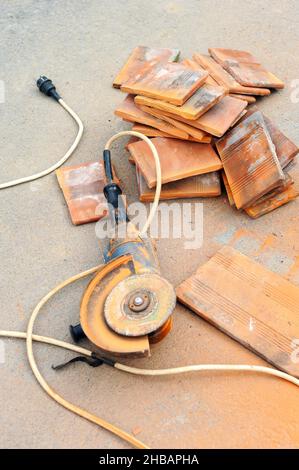 Grinder cuts a tile and brick the electric tool Stock Photo