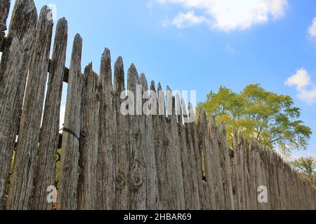 Old rustic weathered wood simple and plain picket fence. Stock Photo