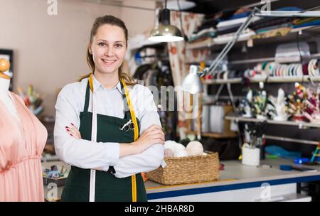 Portrait of woman designer who is standing on her workplace in time designing new collection Stock Photo