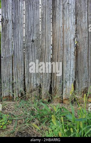 Old rustic weathered wood simple and plain picket fence. Stock Photo