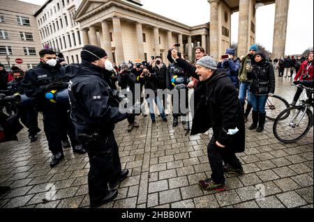 Berlin, Germany. 18th Dec, 2021. A participant of the banned demonstration of opponents of the Corona Rules stretches a fist towards a policeman. The demonstration had been banned by the Berlin police. Credit: Fabian Sommer/dpa/Alamy Live News Stock Photo