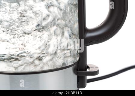 Part of a close-up electric glass kettle for boiling water for hot drinks. With boiling and bubbling transparent water. Stock Photo