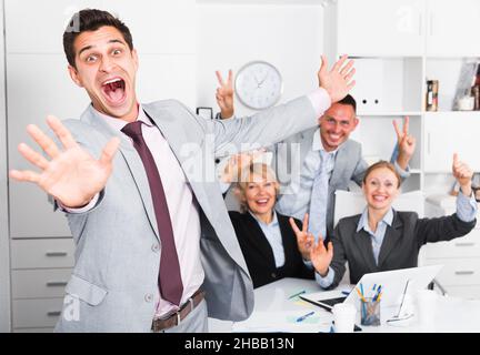 Smiling businessman and team delighted with achievements Stock Photo