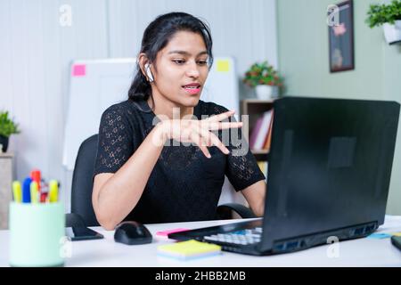 young india businesswoman convincing client about project on video call while working at office - concept of business skills, woman empowerment and co Stock Photo