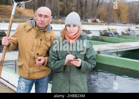 Male farmer with female worker on fish farm Stock Photo