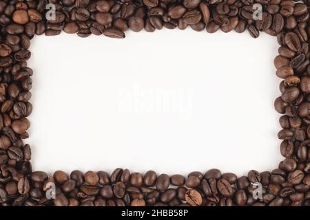 Frame made of roasted coffee beans on white background. Top view, close up, place for text. Stock Photo