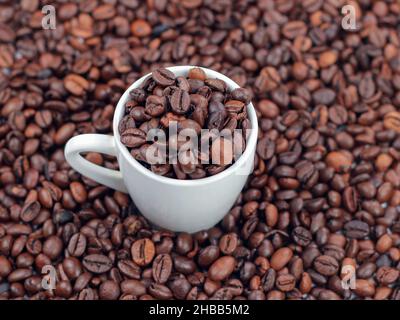Roasted coffee beans and a white cup. Stock Photo