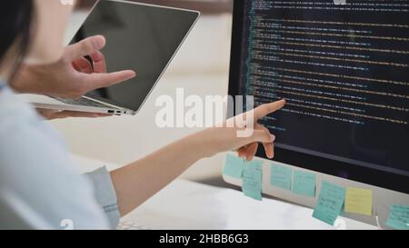 A team of programmers are checking the code on the computer screen. Stock Photo