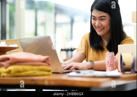 Woman selling products online video calling with smiling customers, Selling products online, Delivering parcels. Stock Photo