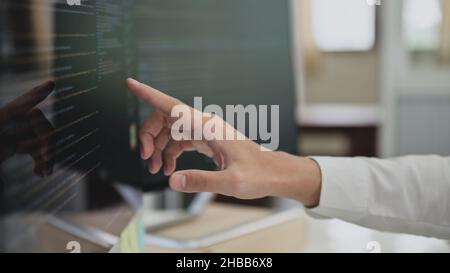Close up shot of Programmers pointing fingers at the code on a computer screen, Computer programming, Learning programming. Stock Photo
