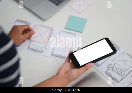 Application designers are designing on smartphone apps, UX, UI concepts. Stock Photo