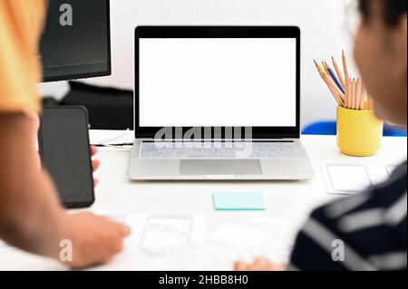 Graphic designer team working with a blank screen laptop on the desk. Stock Photo