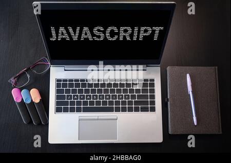 Top view of laptop with text Javascript. JavaScript inscription on laptop screen and keyboard. Learn programming language, computer courses, training. Stock Photo