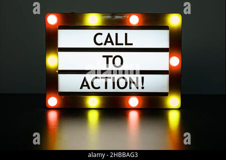 Lightbox with red and orange lights in dark room with words - call to action! Stock Photo