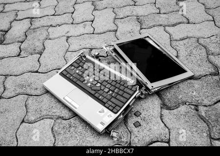 JOHANNESBURG, SOUTH AFRICA - Aug 09, 2021: A broken laptop computer on a brick paving Stock Photo