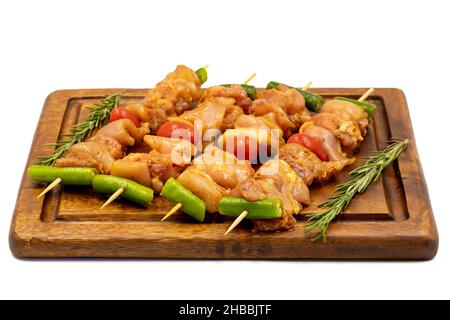 Raw chicken skewers isolated on white background. Close-up of raw chicken skewers marinated in tomato sauce. Horizontal view. Stock Photo