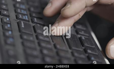 Close-up of finger over black laptop keys pressing enter button, computers and technologies concept. Man finger pushing enter key on black laptop keyb Stock Photo