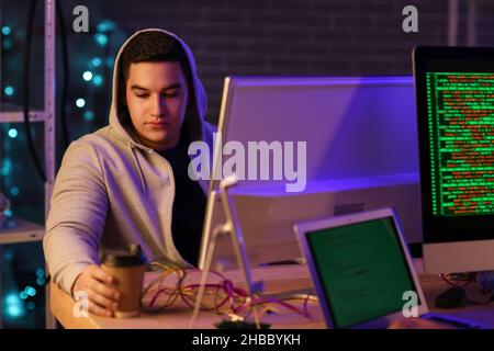 Hacker in dark room with computers Stock Photo