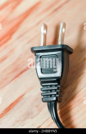 Power supply Electricity plug on brown wooden closeup - Image Stock Photo