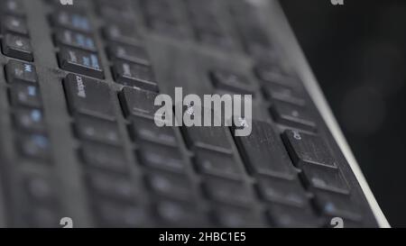 Close-up of finger over black laptop keys pressing enter button, computers and technologies concept. Man finger pushing enter key on black laptop keyb Stock Photo