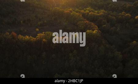Panoramic view in beautiful orange sunset day of a vast hills and mountains in pristine region of Central America. Aerial of green hills covered with Stock Photo