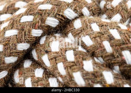 Macro photo of a brown rope with white details made of cotton and jute. Stock Photo