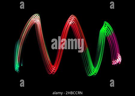 Light Neon Trails Colorful Wave Isolated on black background. Futuristic Colorful Overlay Light Pattern. Stock Photo