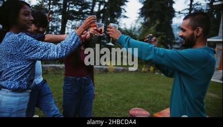Group of young Indian friends drinking and dancing during an outdoor party Stock Photo