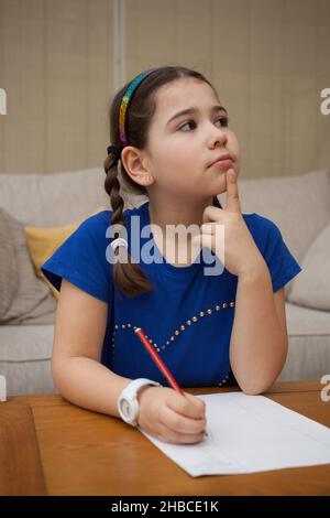 A girl at home doing sums in her head Stock Photo