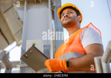 Serious young worker standing at industrial site Stock Photo