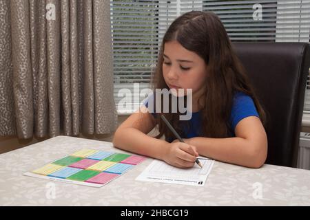 A girl doing her maths school homework, taken 13th of August 2020 in Wool, Dorset, UK Stock Photo