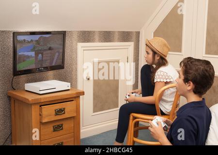 A brother and sister play Minecraft on their Xbox together, taken on the 13th of August in Wool, Dorset, UK Stock Photo