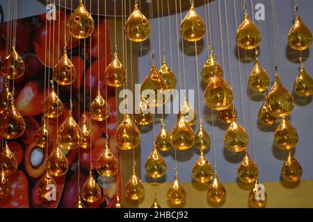 Beautiful decorative chandelier hanging as waterfall from ceiling as modern fashionable minimalist lighting ornament made of luxury glass, crystal. Stock Photo
