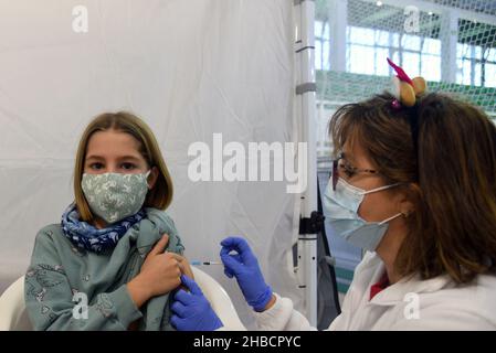 Calafell, Tarragona, Spain. 30th Sep, 2021. A nurse administers a dose of Pfizer-BioNTech vaccine to a girl at a vaccination centre.The Department of Health of Catalonia through the Xarxa Santa Tecla de Tarragona in the prevention of the contagion of SARS-CoV-2 Covid-19 and the new contagion strain Ã³micron has administered the first dose of the COMIRNATY vaccine (COVID-19 vaccine mRNA, Pfizer-BioNTech) to boys and girls between 5 and 11 years of age at the vaccination center located at the Joan Ortoll Sports Pavilion in Calafell. (Credit Image: © Ramon Costa/SOPA Images via ZUMA Press Wi Stock Photo