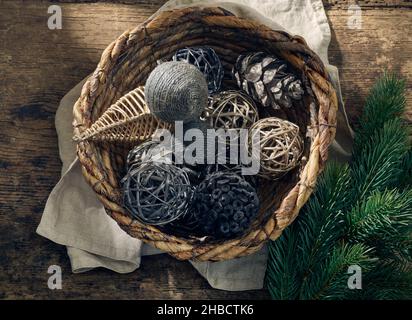 Christmas decorations in a wicker basket on old wooden table, top view Stock Photo