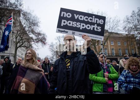 A protester is seen holding a placard of 'no vaccine passports' during the demonstration. Following the introduction of covid 19 vaccination passport as part of the measures to limit the spread of Omicron covid 19 variant in the UK last week, people walk on the street to protest against the mandatory covid 19 vaccination and the use of covid 19 vaccination passport as part of the covid 19 restrictions. They demanded the 'freedom' to choose to be vaccinated or not and not to be restricted by the covid 19 vaccination passport. Stock Photo