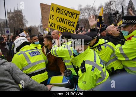 London, UK. 18th Dec, 2021. Police scuffling with protesters trying to prevent a blockade of the street, during the demonstration. Anti vaccine and anti vaccine pass protesters joined by opponents of Covid 19 restrictions, gathered at Parliament Square and marched through central London. Credit: SOPA Images Limited/Alamy Live News Stock Photo
