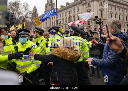 London, UK. 18th Dec, 2021. Police scuffling with protesters trying to prevent a blockade of the street, during the demonstration. Anti vaccine and anti vaccine pass protesters joined by opponents of Covid 19 restrictions, gathered at Parliament Square and marched through central London. Credit: SOPA Images Limited/Alamy Live News Stock Photo