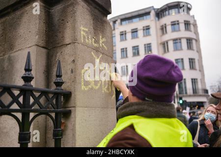 London, UK. 18th Dec, 2021. (EDITOR'S NOTE: Image contains profanity)A protester writes on the wall an anti Boris Johnson slogan, during the demonstration. Anti vaccine and anti vaccine pass protesters joined by opponents of Covid 19 restrictions, gathered at Parliament Square and marched through central London. Credit: SOPA Images Limited/Alamy Live News Stock Photo