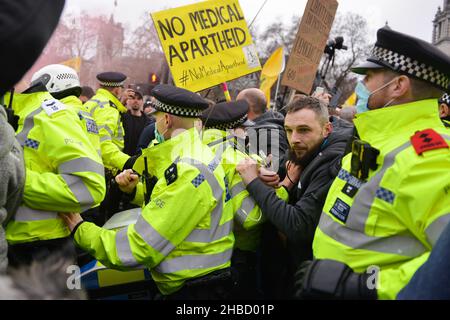 London, UK. 18th Dec, 2021. Police scuffling with protesters trying to prevent a blockade of the street, during the demonstration. Anti vaccine and anti vaccine pass protesters joined by opponents of Covid 19 restrictions, gathered at Parliament Square and marched through central London. (Photo by Thomas Krych/SOPA Images/Sipa USA) Credit: Sipa USA/Alamy Live News Stock Photo