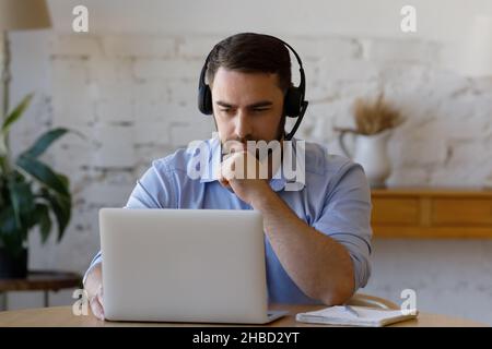 Concentrated young man holding video call meeting. Stock Photo