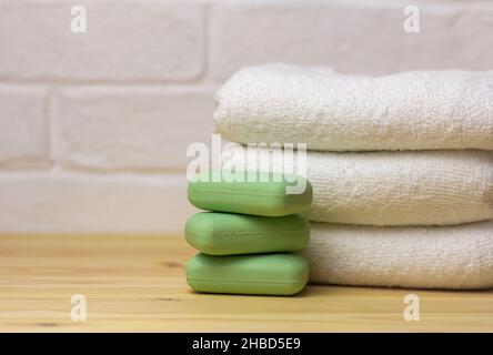 A stack of clean white towels and soap on the table Stock Photo