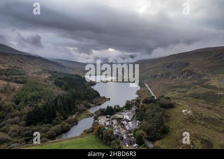 Epic aerial flying drone landscape image of Snowdon Massif viewed from above Llynau Mymber during Autumn sunset Stock Photo