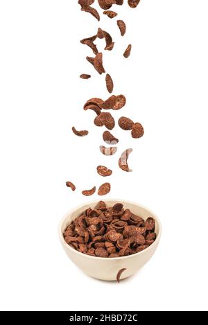 Chocolate corn flakes falling to the white bowl isolated on white. Motion. Copyspace. Stock Photo