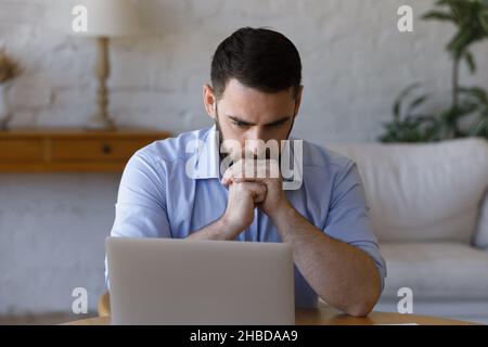 Stressed young businessman looking at computer screen. Stock Photo