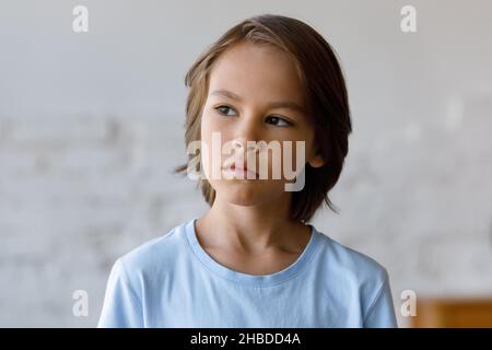 Unhappy lost in thoughts 12s kid boy looking in distance. Stock Photo