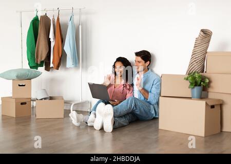 Happy millennial couple using laptop after relocation Stock Photo